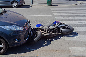 Motorcycle under car after crash