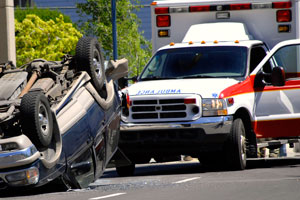 An overturned vehicle and ambulance with an injured victim will often call Tampa car accident lawyers.