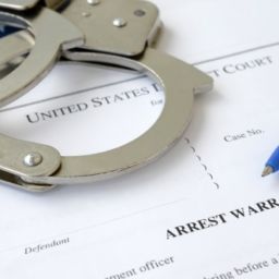 Arrest Warrant paperwork and handcuffs