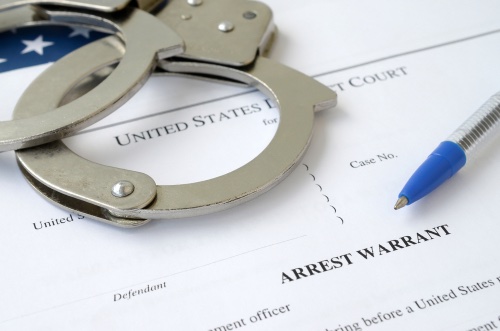 Arrest Warrant paperwork and handcuffs